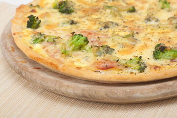 Pizza mit Schinken, frische Tomaten, Broccoli und Sauce Hollandaise