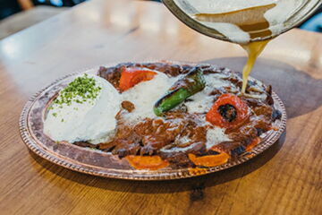 Grillfleisch auf Fladenbrot mit gerösteten Tomaten, Joghurt und Tomatensoße