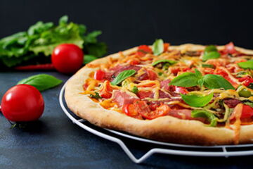 Pizza mit Salami, Schinken, Champignons, Thunfisch, Artischocken und Zwiebeln (Goudakäse überbacken)